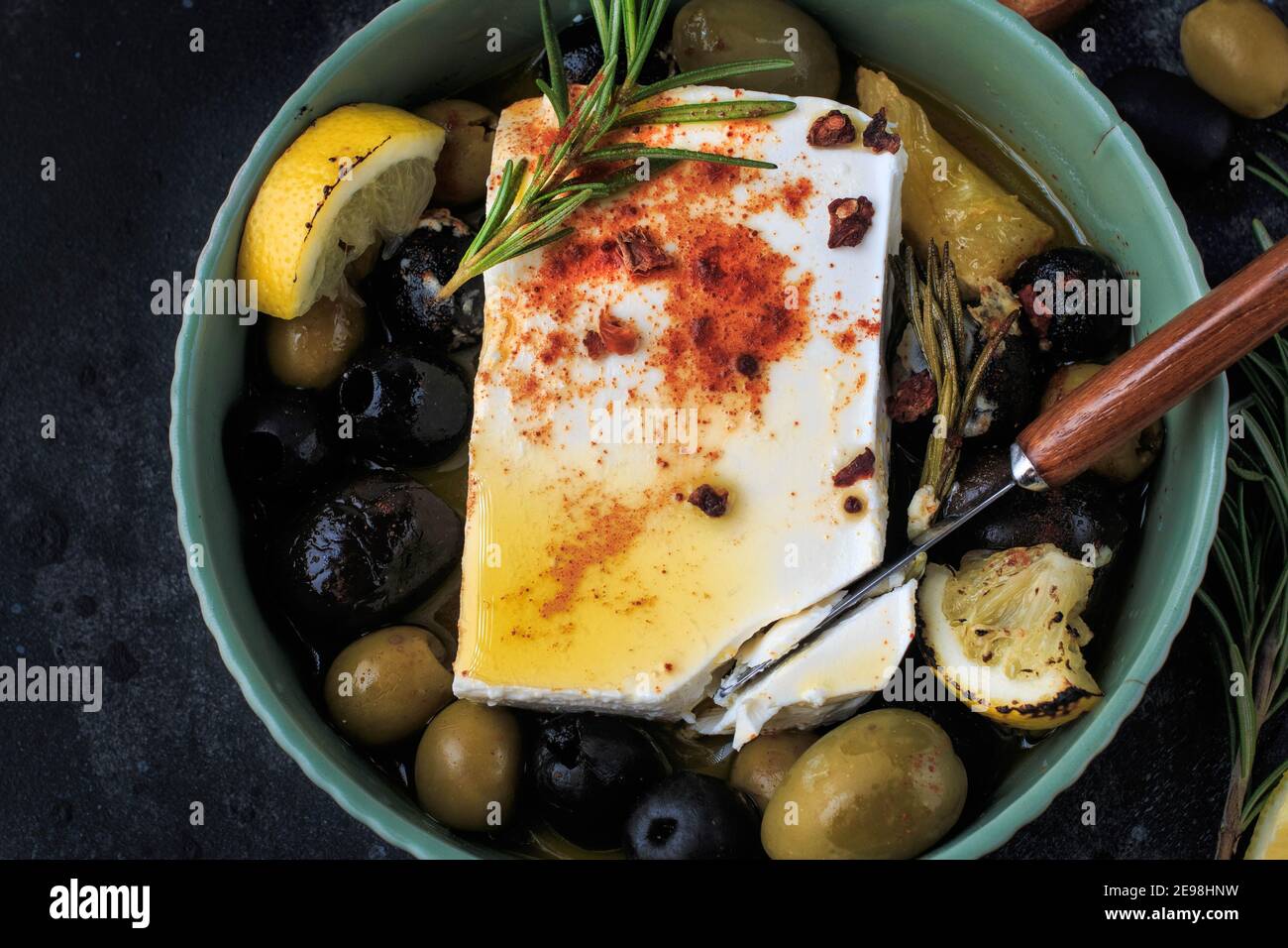 Fromage feta cuit au four avec citron, olives et romarin. Banque D'Images