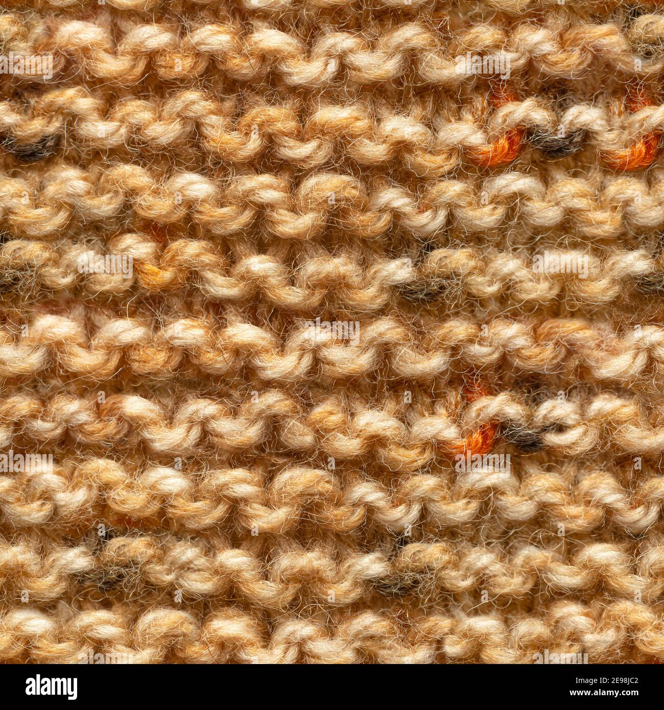 Tissu tricoté marron jaune sans couture pour un garnissage sans bordure. Tissu tricoté à motif répétitif pour un gros plan sur l'arrière-plan. Banque D'Images