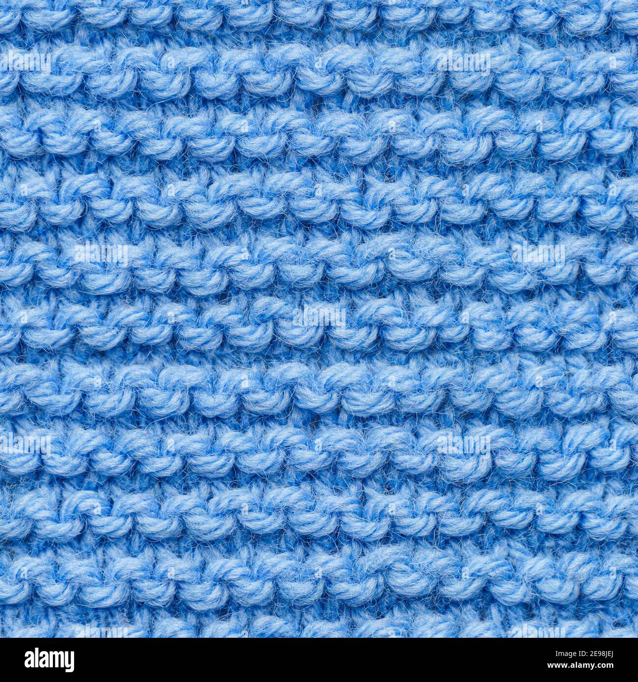 Tissu tricoté bleu sans couture pour un garnissage sans bordure. Tissu tricoté à motif répétitif pour un gros plan sur l'arrière-plan. Banque D'Images