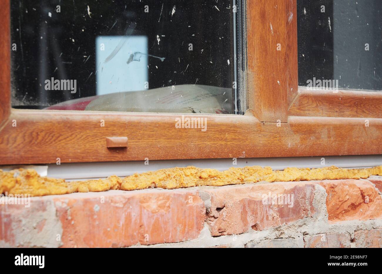 Installation d'une fenêtre en plastique dans une maison en brique avec isolant en mousse pour pistolet à calfeutrer. Banque D'Images