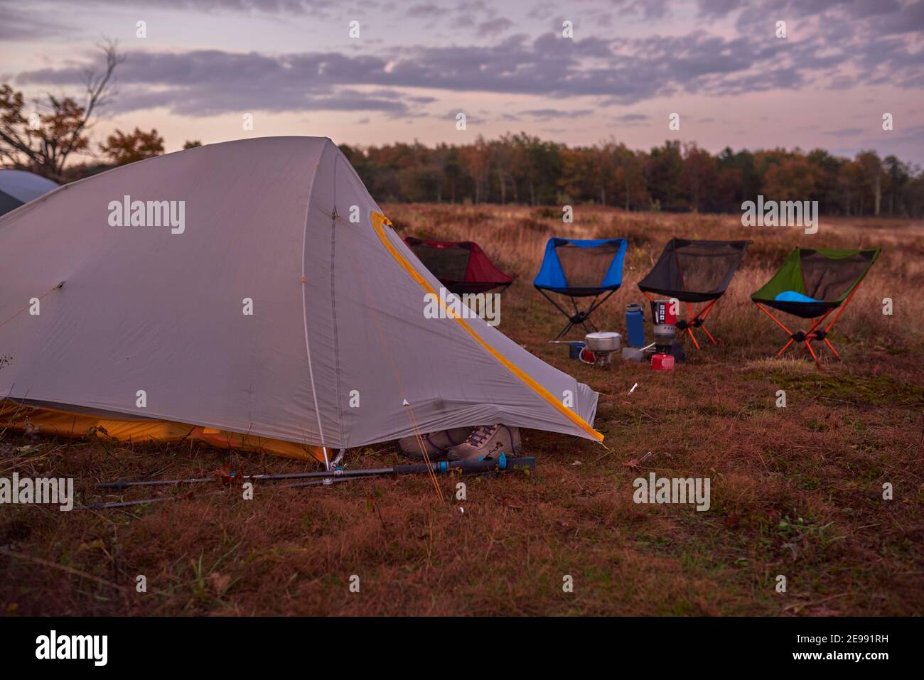 Illuminé les tentes de remballage dans le champ juste avant le lever du soleil. Banque D'Images
