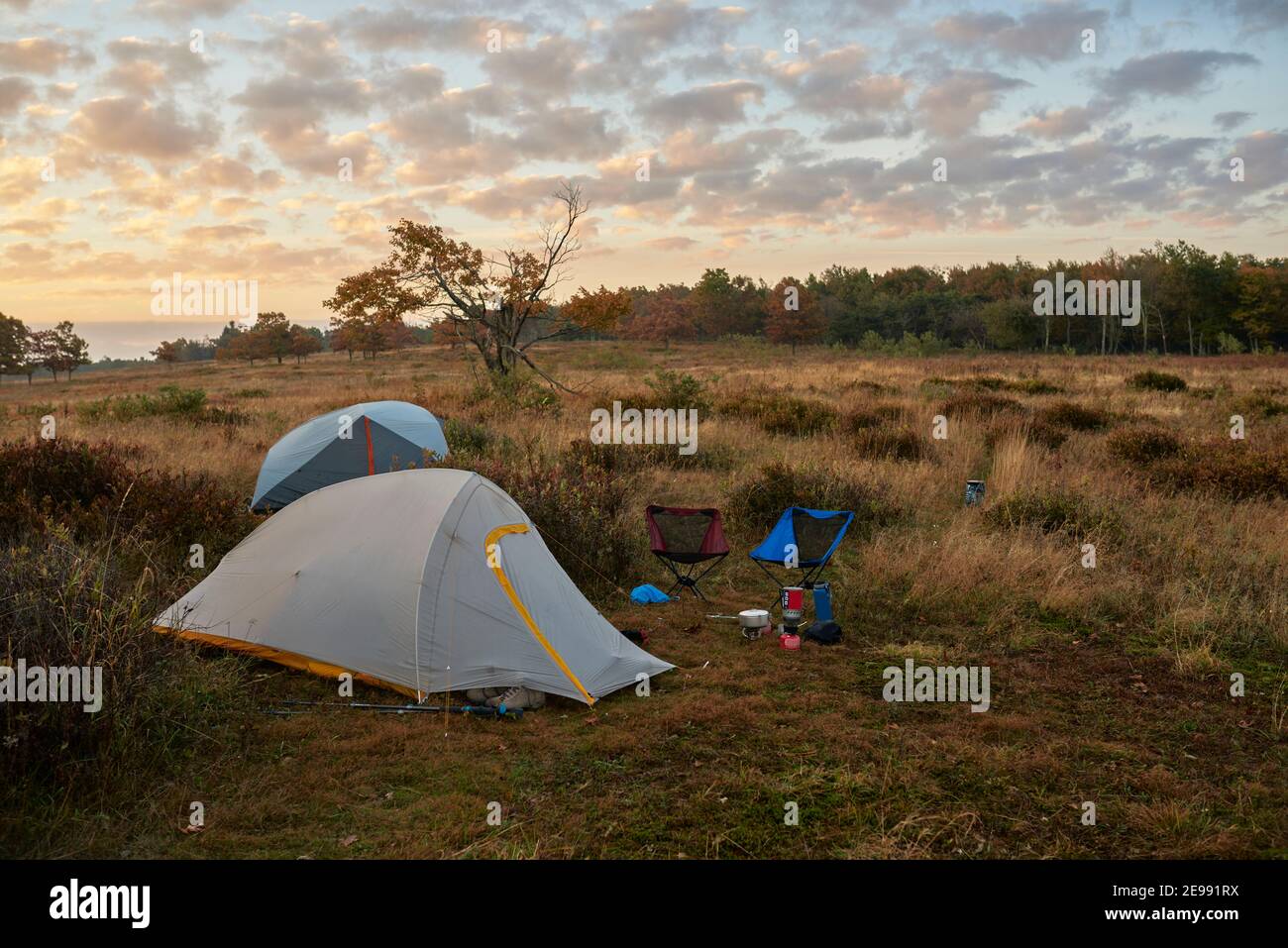Illuminé les tentes de remballage dans le champ juste avant le lever du soleil. Banque D'Images