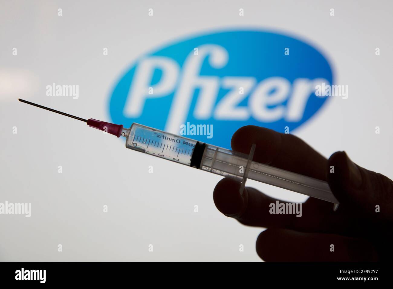 OXFORD, Royaume-Uni - février 2020 : une seringue de vaccin covid devant le logo pfizer Banque D'Images