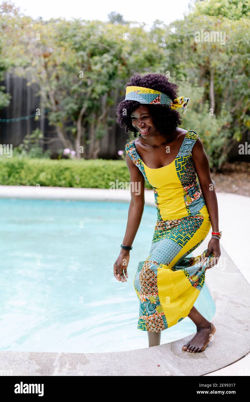 Belle femme pieds nus dans la piscine portant une robe et un bandeau  africains Photo Stock - Alamy
