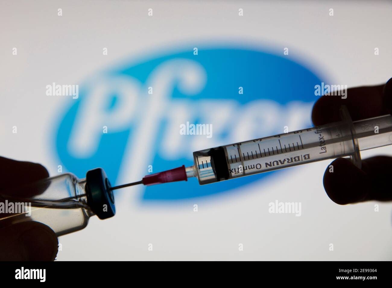 OXFORD, Royaume-Uni - février 2020 : une seringue de vaccin covid devant le logo pfizer Banque D'Images