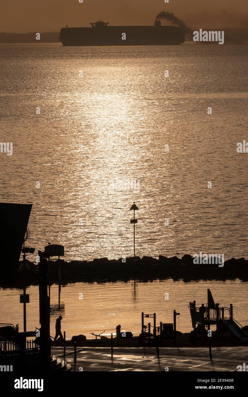 Southend on Sea, Essex, Royaume-Uni. 3 février 2021. HMM le Havre est vu passer Southend on Sea sur l'estuaire de la Tamise en fin d'après-midi, laissant une piste de fumée après avoir quitté le port DP World London Gateway. Le navire conteneur de classe Algeciras est l'un des plus grands jamais construit, entrant en service en août 2020, capable de transporter près de 24000 conteneurs, et dessert l'extrême-Orient Europe 3 boucle route. Le Royaume-Uni demande à adhérer à l'Accord global et progressif pour le Partenariat transpacifique (CPPTP), qui inclut les pays de l'extrême-Orient desservis par des navires géants comme celui-ci. En passant par l'aire de jeux de lagon en bord de mer Banque D'Images