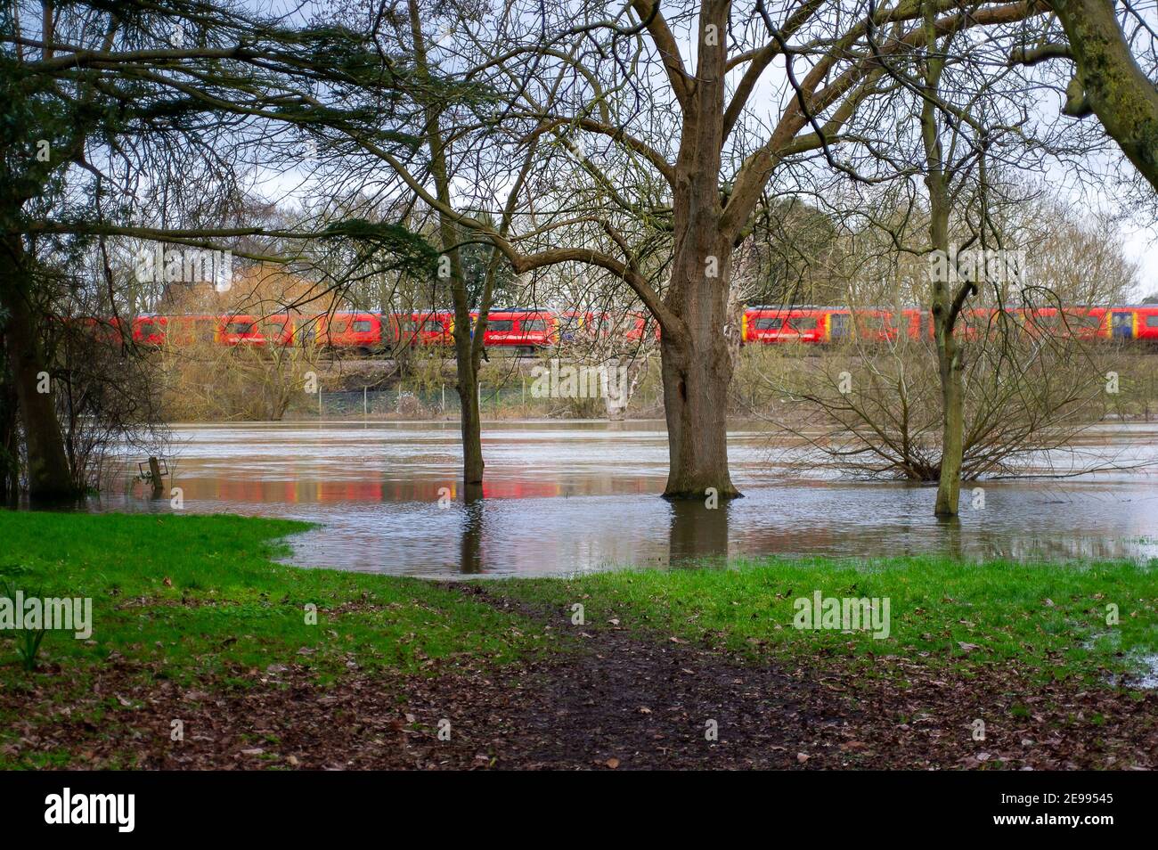 Eton, Windsor, Berkshire, Royaume-Uni. 3 février 2021. Un train à destination de Waterloo passe par les terrains de jeu inondés du Eton College. Une alerte d'inondation demeure en place le long de la Tamise, de Maidenhead à Windsor et Eton. On s'attend à ce que les niveaux des cours d'eau demeurent élevés pendant les prochains jours, mais on ne s'attend pas actuellement à des inondations. Crédit : Maureen McLean/Alay Live News Banque D'Images