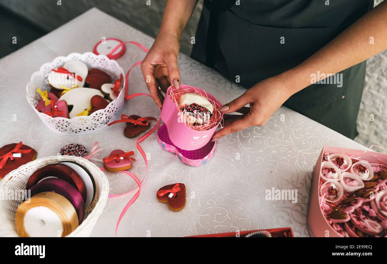 les paquets pour filles dans une boîte cadeau gâteaux en forme de coeur. Préparation pour la célébration. Banque D'Images