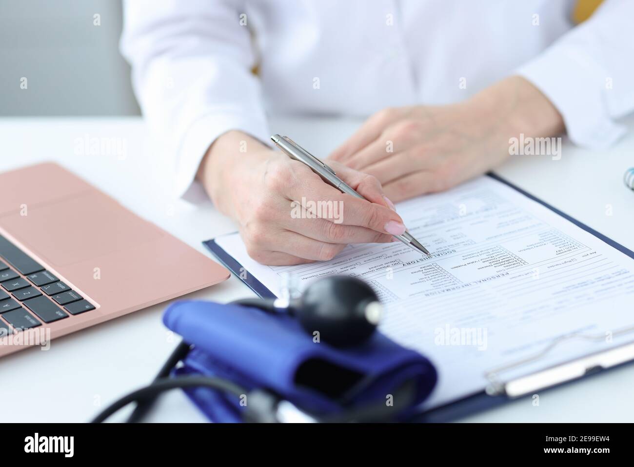 Médecin remplissant les antécédents médicaux des patients en clinique de près Banque D'Images