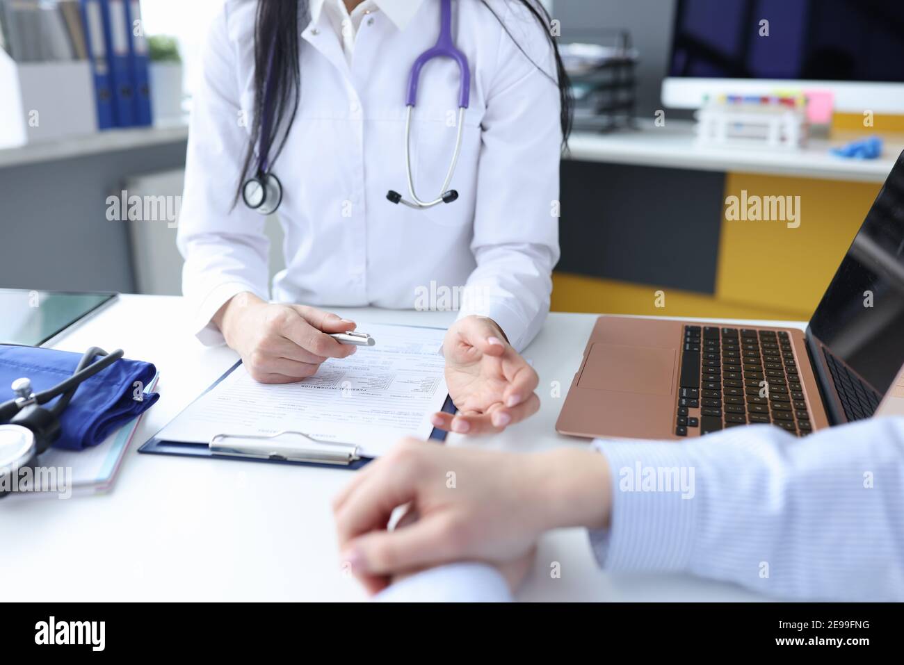 Médecin à l'écoute des plaintes des patients dans le bureau fermé Banque D'Images
