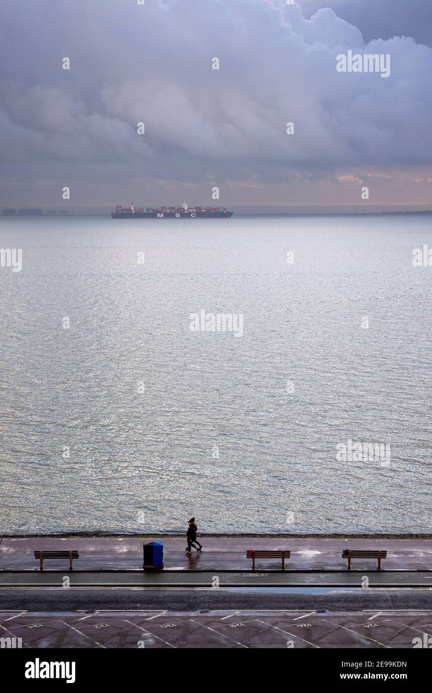 Grande étendue d'eau de mer de l'estuaire de la Tamise en fin d'après-midi, près de la tombée de la nuit à Southend on Sea, Essex, Royaume-Uni. Le navire à conteneurs MSC Hamburg passe Banque D'Images