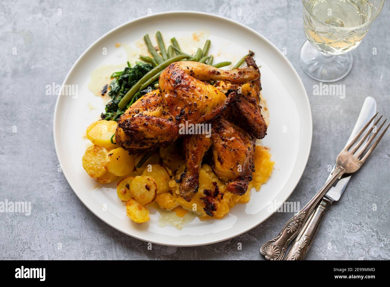 poussin rôti avec pommes de terre, chou-rafles, haricots verts et épinards crémeux Banque D'Images