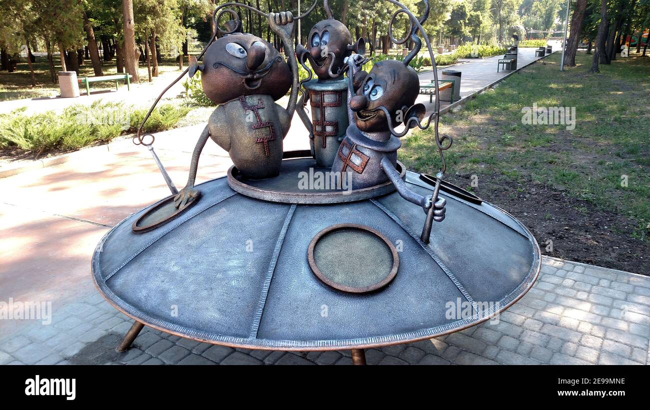 Soucoupe volante en acier avec des extraterrestres amusants dans le parc de la ville. Banque D'Images