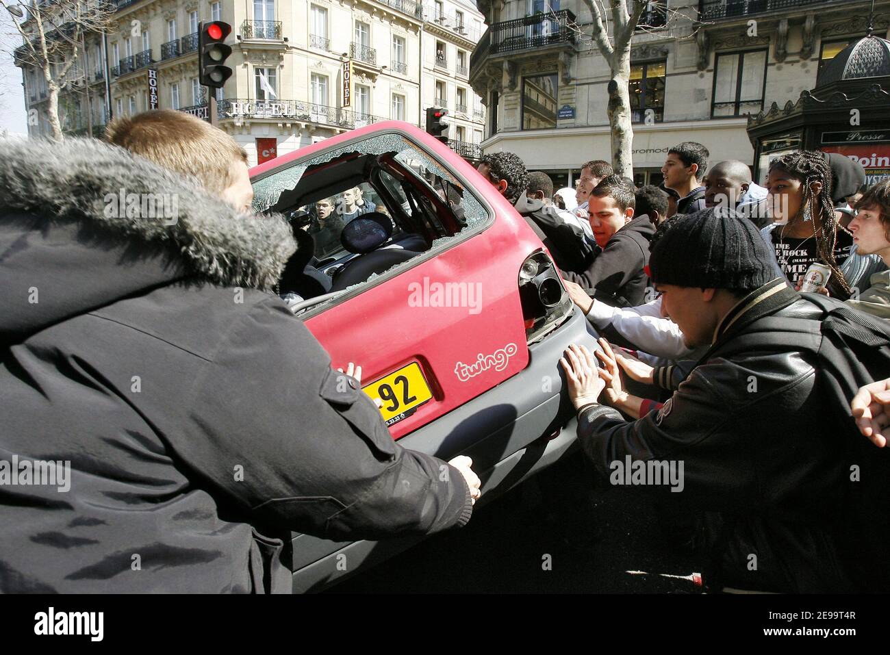 Un accident majeur se produit lors d'un nouveau contrat de travail anti-CPE (nouveau contrat de travail pour les jeunes) à Paris, France, le 7 avril 2006. Pendant que la manifestation se dirigeait sur le boulevard Saint-Michel, un conducteur furieux a tenté de passer avec sa Renault rouge à travers les manifestants. Quatre marcheurs ont été frappés par la voiture et le conducteur était en chemin pour s'échapper quand d'autres manifestants pendaient sur la voiture. Après avoir poinçonné la Renault de plusieurs manières, ils décident de mettre la voiture à l'envers tandis que le conducteur était encore au volant. Heureusement pour lui, la police française arrive à temps pour sauver le mime de la foule furieuse. Photo de Mehdi Taamallah Banque D'Images