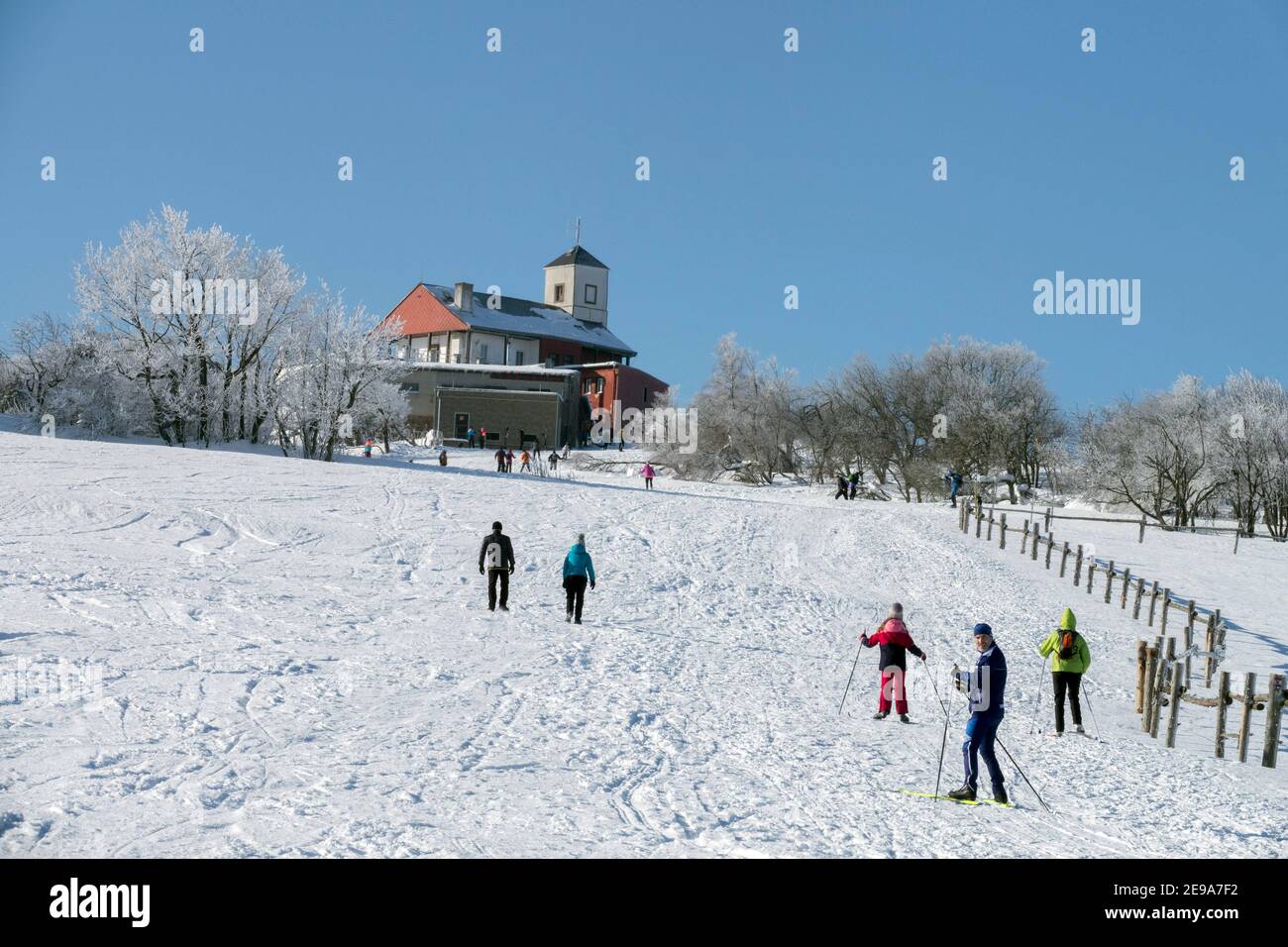 Le chalet de montagne Komari Hurka est sur la crête de la Les montagnes d'ORE la République tchèque les paysages enneigés et les gens skier dessus un pré de montagne Banque D'Images