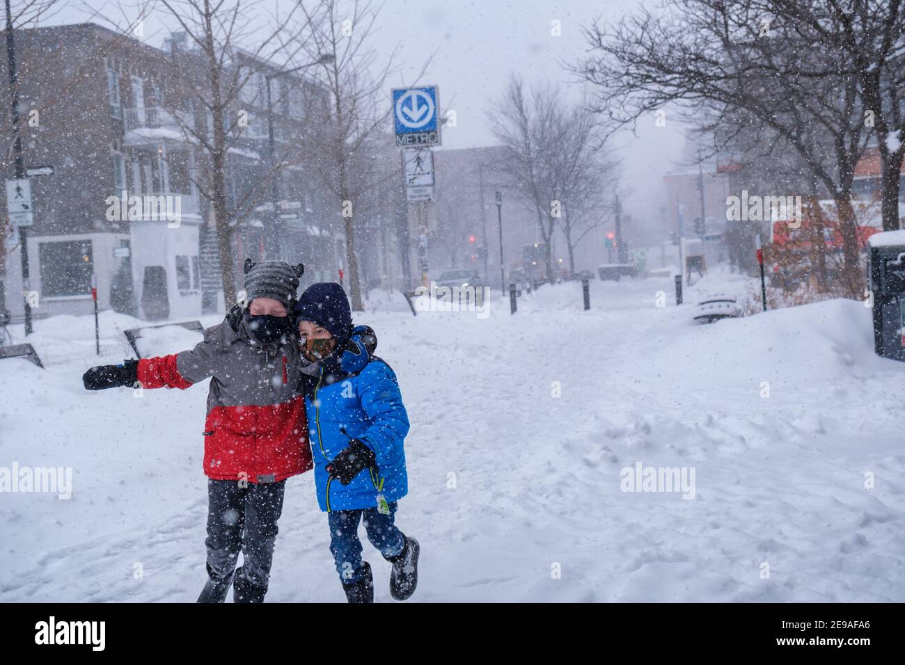 Montréal, CA - 2 février 2021 : deux enfants souriants s'amusent pendant la tempête de neige Banque D'Images