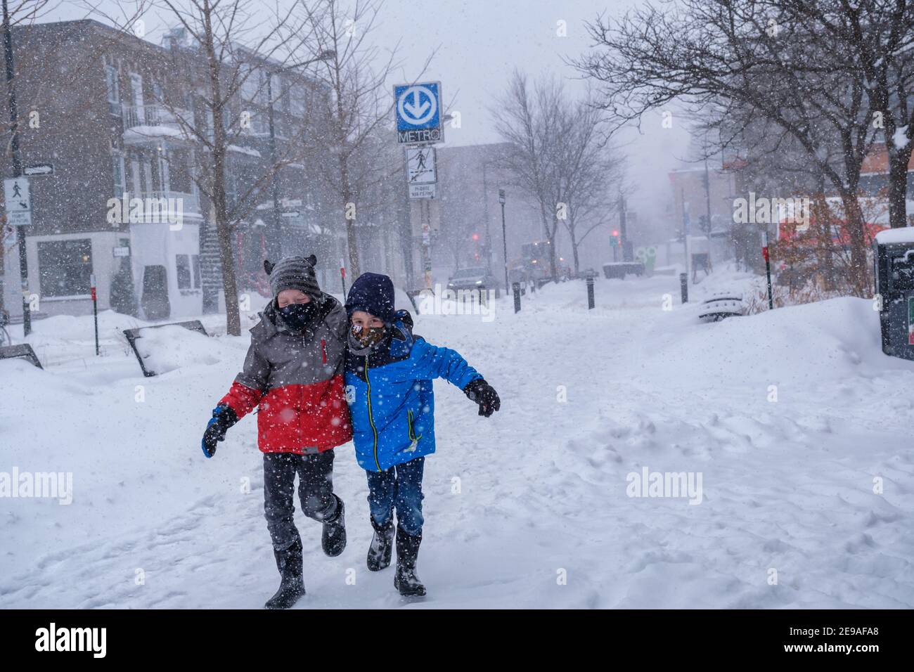 Montréal, CA - 2 février 2021 : deux enfants souriants s'amusent pendant la tempête de neige Banque D'Images