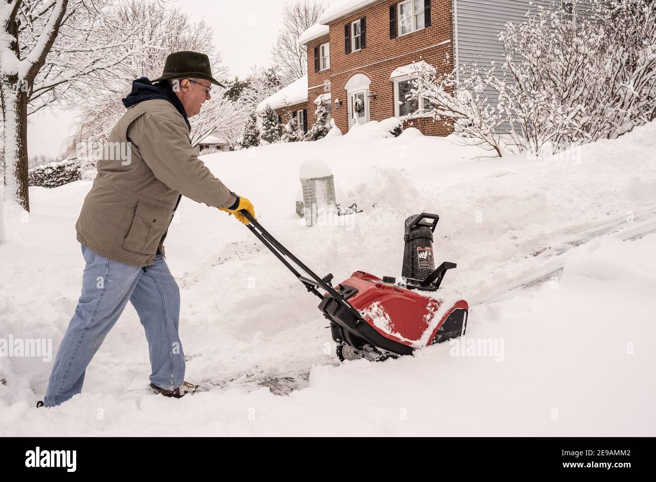 Comté de Berks, Pennsylvanie-2 février 2021 : homme âgé utilisant un souffleur de neige pour nettoyer son trottoir et son allée après une tempête de neige Banque D'Images