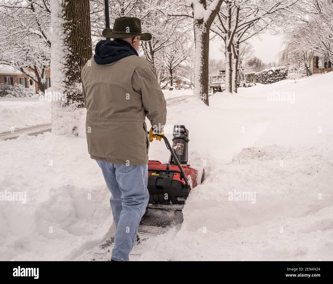 Comté de Berks, Pennsylvanie-2 février 2021 : homme âgé utilisant un souffleur de neige pour nettoyer son trottoir et son allée après une tempête de neige Banque D'Images