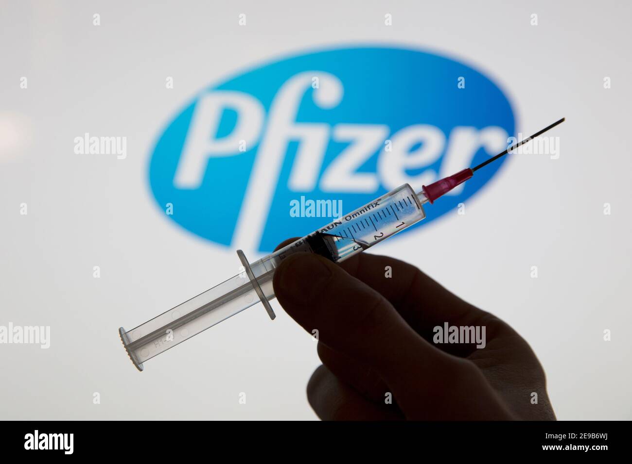 OXFORD, Royaume-Uni - février 2020 : une seringue de vaccin covid devant le logo pfizer Banque D'Images