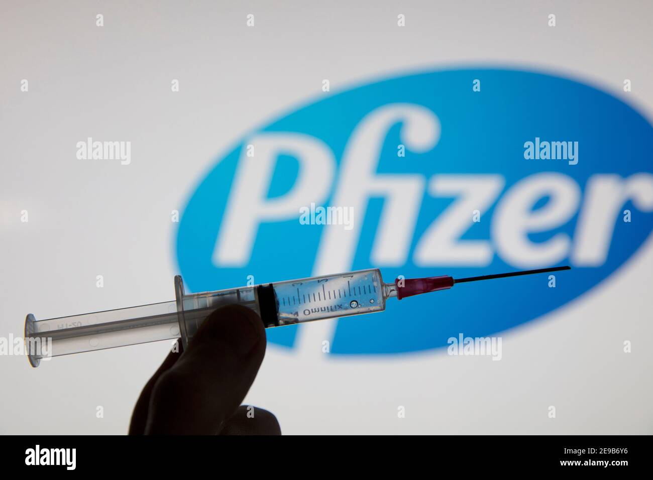 OXFORD, Royaume-Uni - février 2020 : une seringue de vaccin covid devant le logo pfizer Banque D'Images