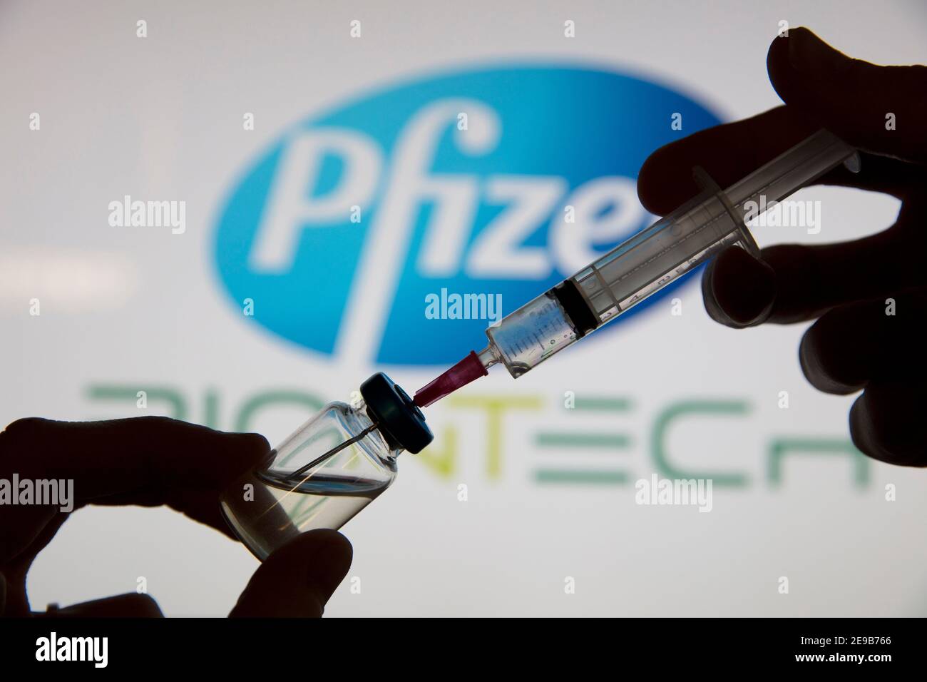 OXFORD, Royaume-Uni - février 2020 : une seringue de vaccin covid devant le logo pfizer Banque D'Images