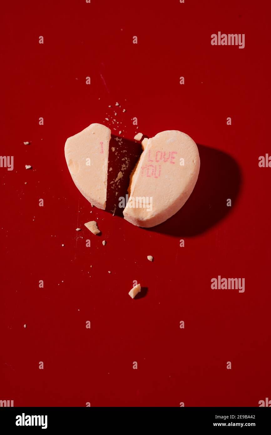 Un cœur de conversation de bonbons cassé avec l'imprimé « I Love You » sur elle Banque D'Images