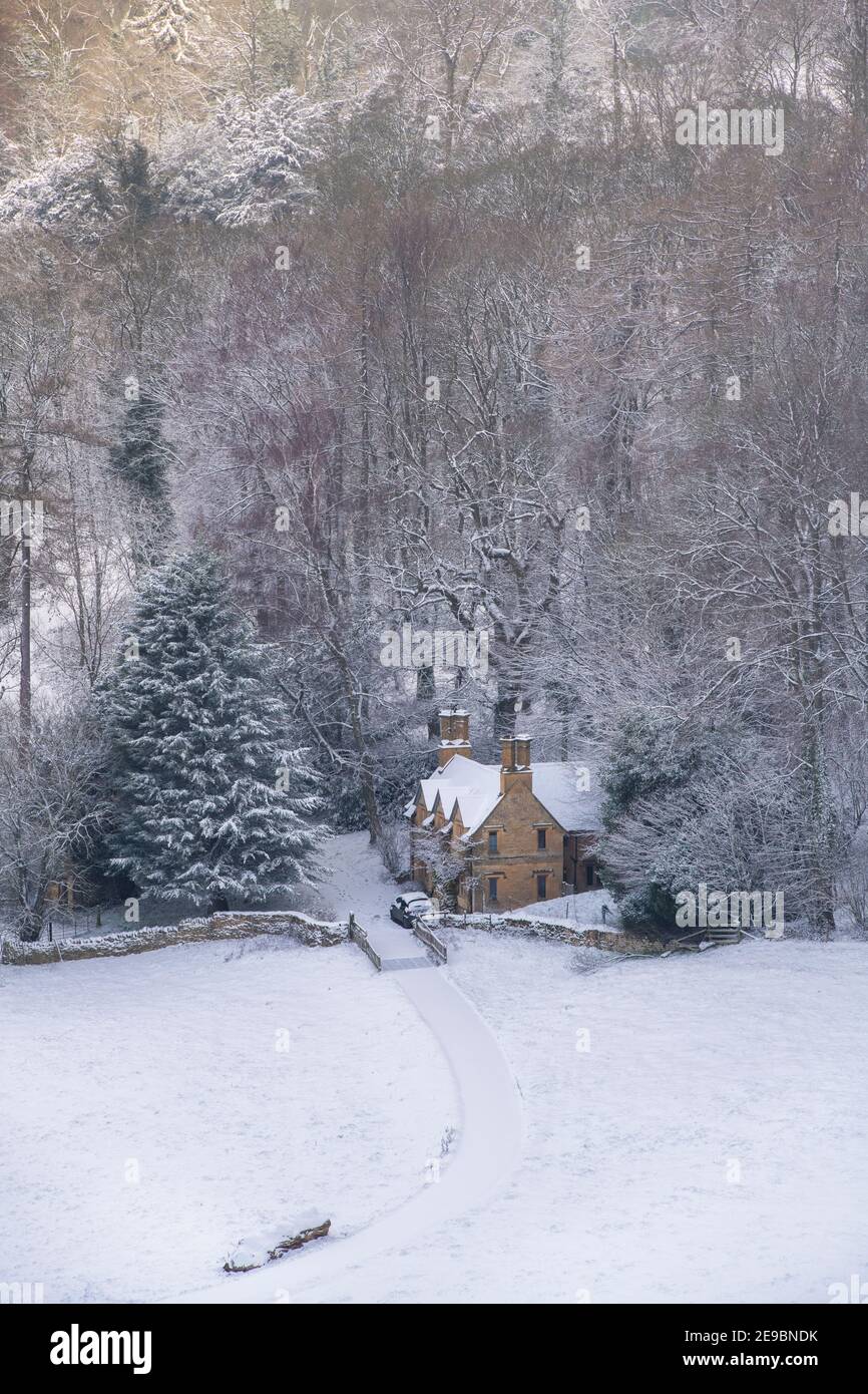 Cotswold cottage dans la neige au bord d'une forêt. Lower Coscombe, Cotswolds, Gloucestershire, Angleterre Banque D'Images