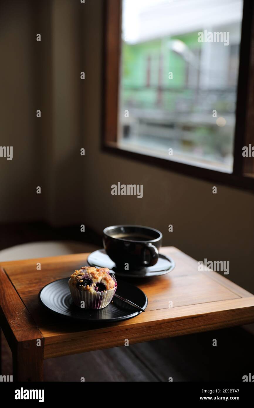 Tasse de café avec muffin sur table en bois dans le café local boutique Banque D'Images