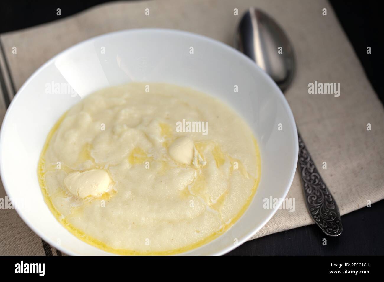 lait boudin chaud ou semoule avec beurre et cuillère sur la table. Le petit déjeuner est prêt Banque D'Images