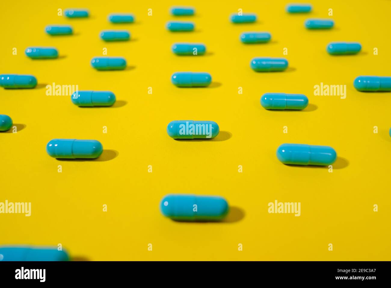 Pilules bleues sur fond jaune. Banque D'Images