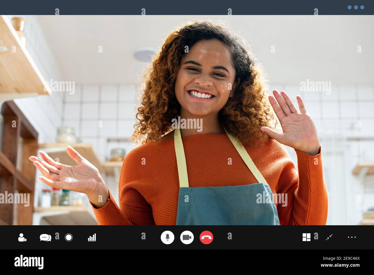 Jolie femme afro-américaine souriant et se branle à la caméra effectuant un appel vidéo dans la cuisine à la maison Banque D'Images