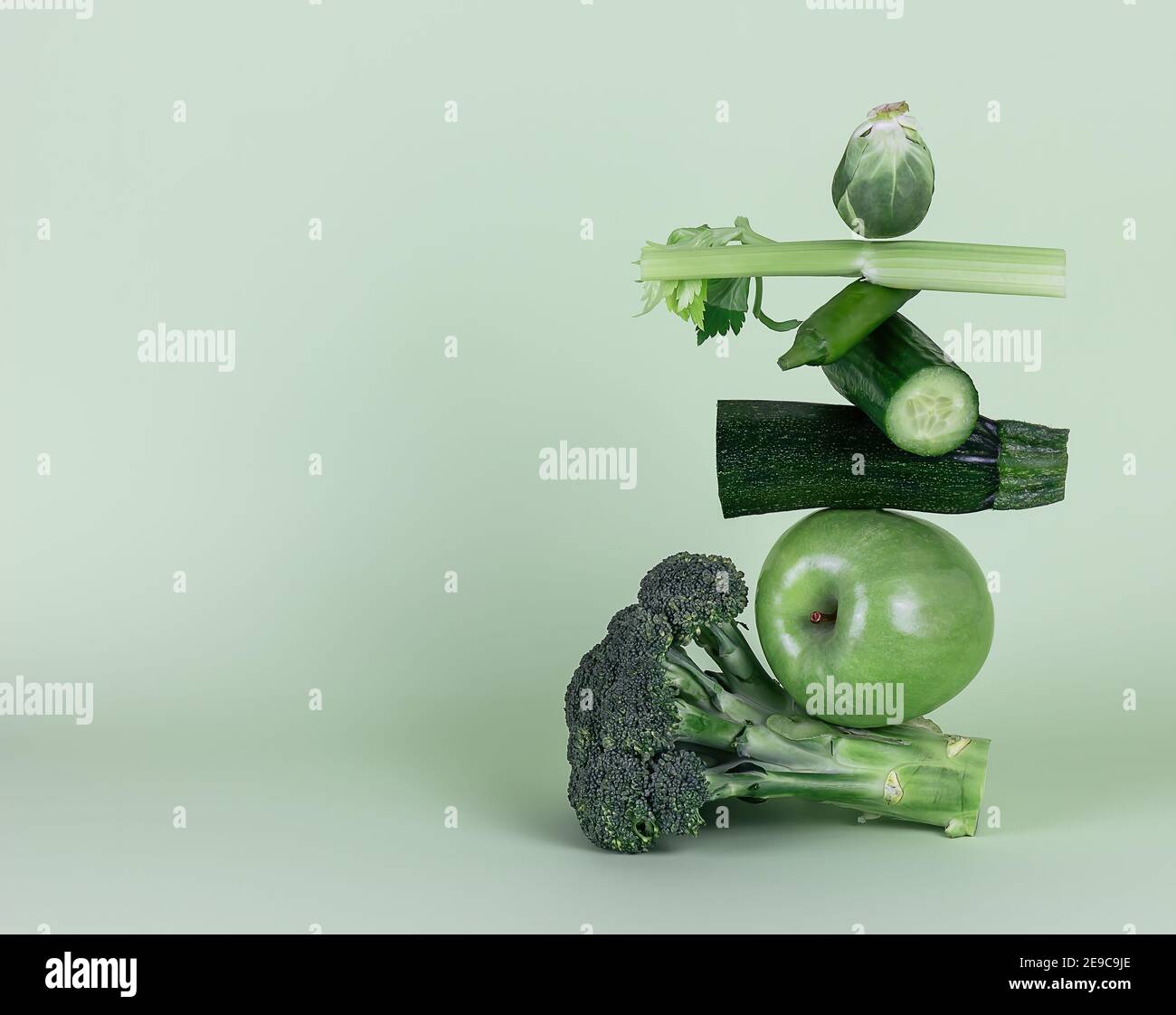 Fruits et légumes verts frais sur fond vert. Équilibre équilibre équilibre alimentaire flottant. Banque D'Images