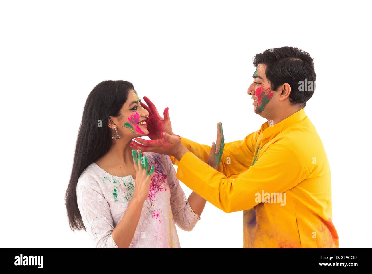 UN JEUNE HOMME METTANT LA COULEUR SUR UNE FEMME PENDANT HOLI Banque D'Images