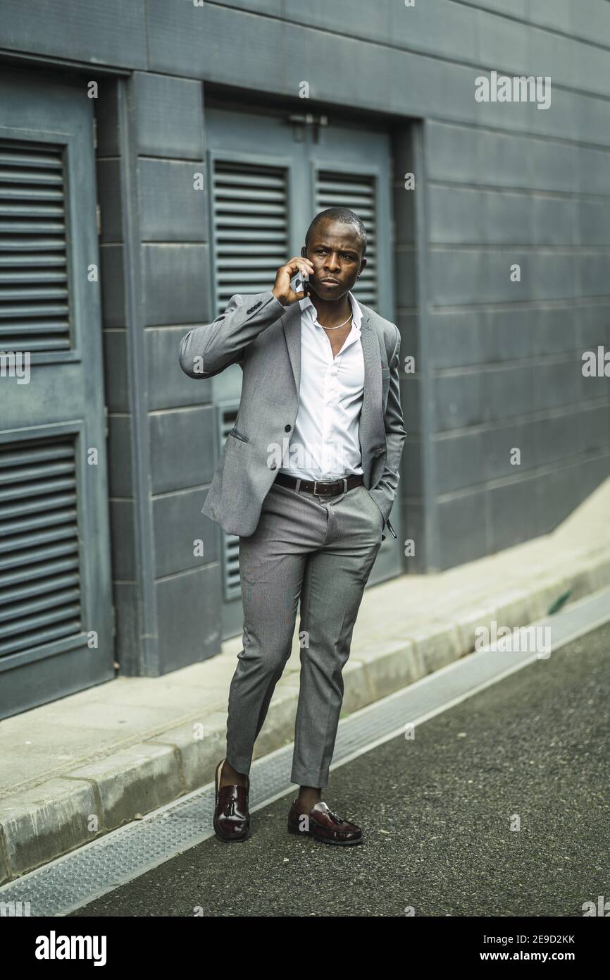 Photo verticale d'un homme africain très confiant dans un je vous le conviendront à parler au téléphone Banque D'Images