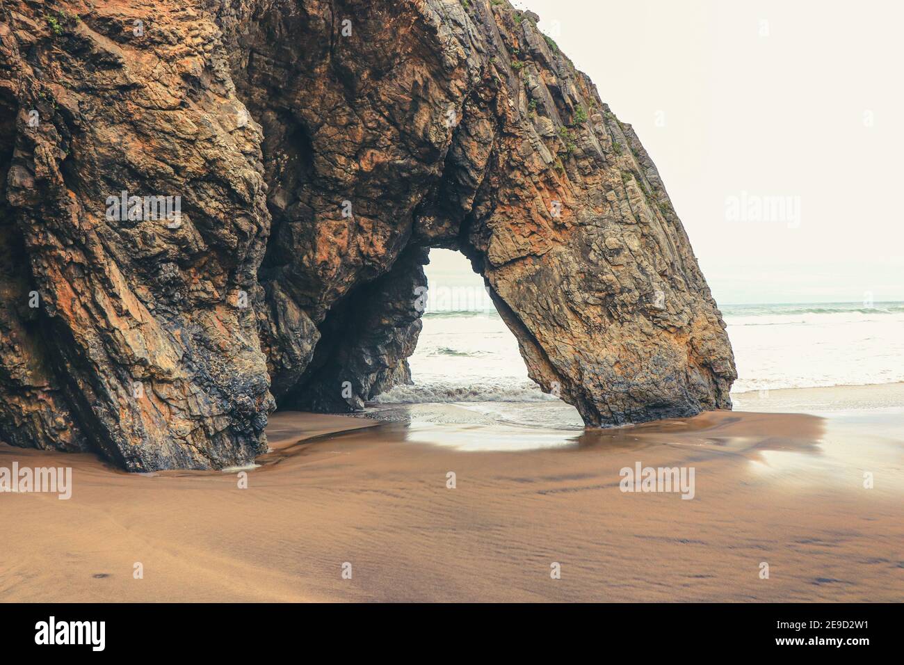 Belle pierre naturelle arche. Formation de roches dans une plage avec l'océan en arrière-plan. Banque D'Images
