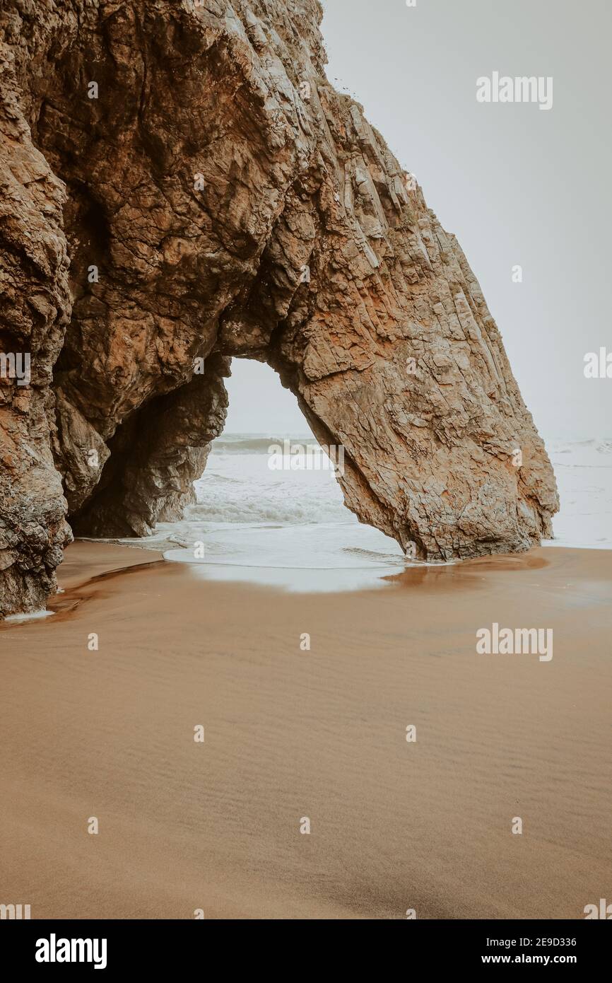 Belle pierre naturelle arche. Formation de roches dans une plage avec l'océan en arrière-plan. Banque D'Images