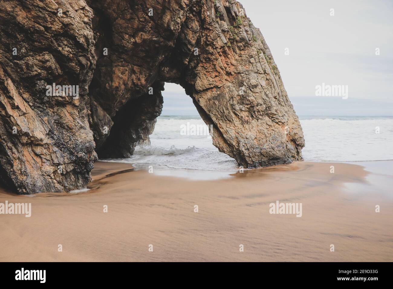 Belle pierre naturelle arche. Formation de roches dans une plage avec l'océan en arrière-plan. Banque D'Images
