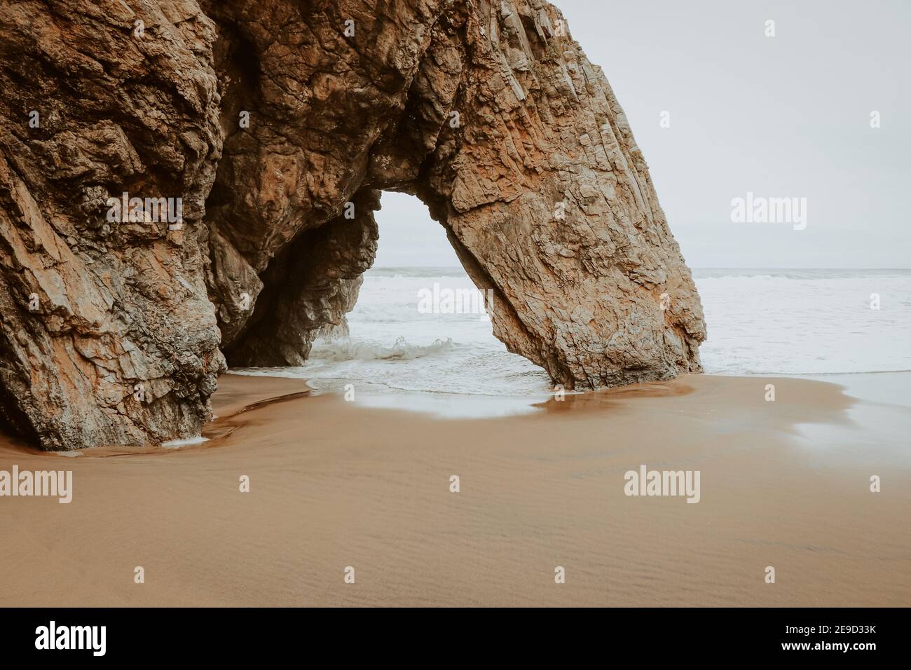 Belle pierre naturelle arche. Formation de roches dans une plage avec l'océan en arrière-plan. Banque D'Images