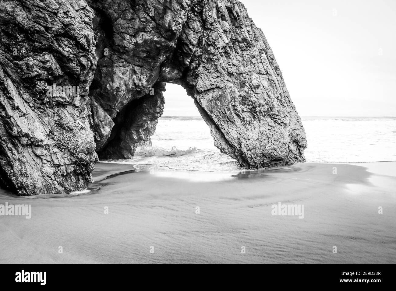 Belle pierre naturelle arche. Formation de roches dans une plage avec l'océan en arrière-plan. Banque D'Images