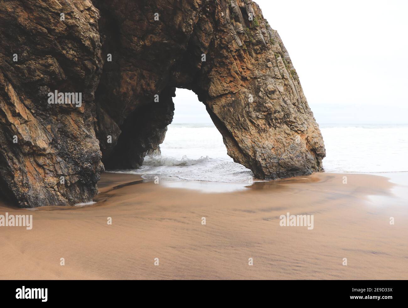 Belle pierre naturelle arche. Formation de roches dans une plage avec l'océan en arrière-plan. Banque D'Images