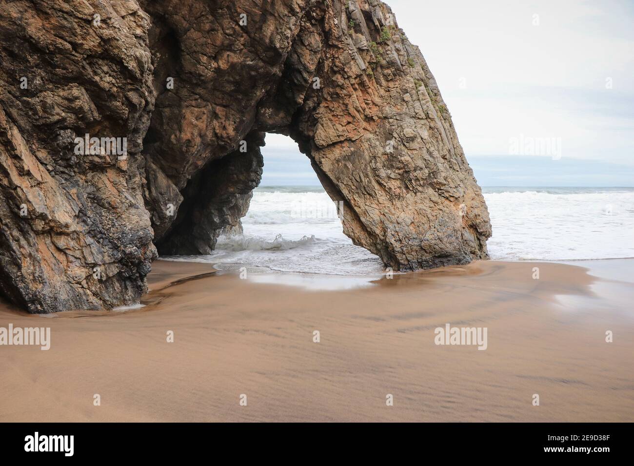 Belle pierre naturelle arche. Formation de roches dans une plage avec l'océan en arrière-plan. Banque D'Images