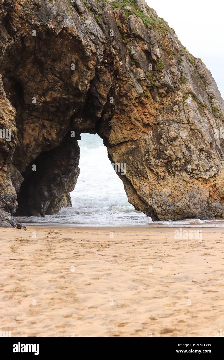 Belle pierre naturelle arche. Formation de roches dans une plage avec l'océan en arrière-plan. Banque D'Images