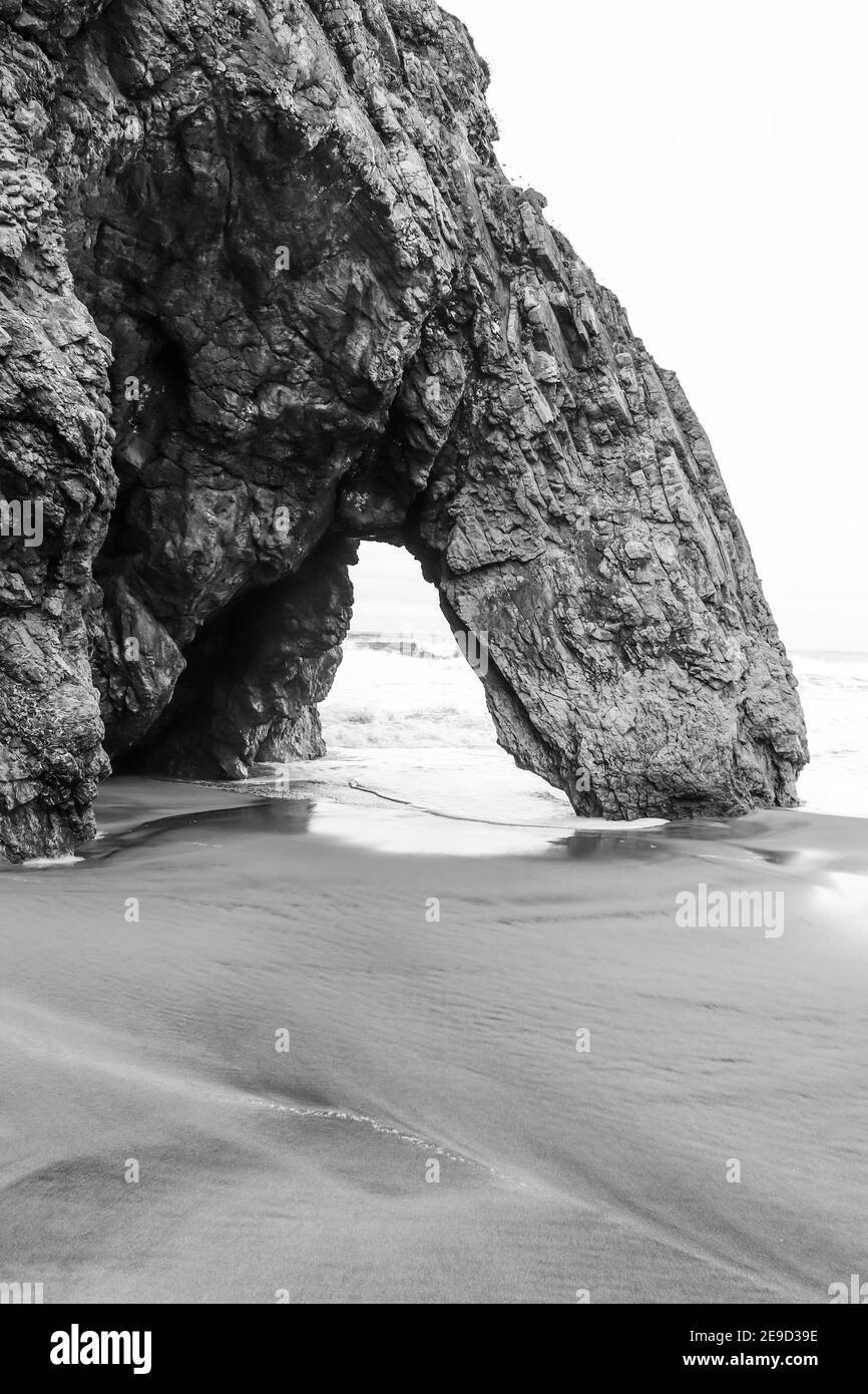Belle pierre naturelle arche. Formation de roches dans une plage avec l'océan en arrière-plan. Banque D'Images