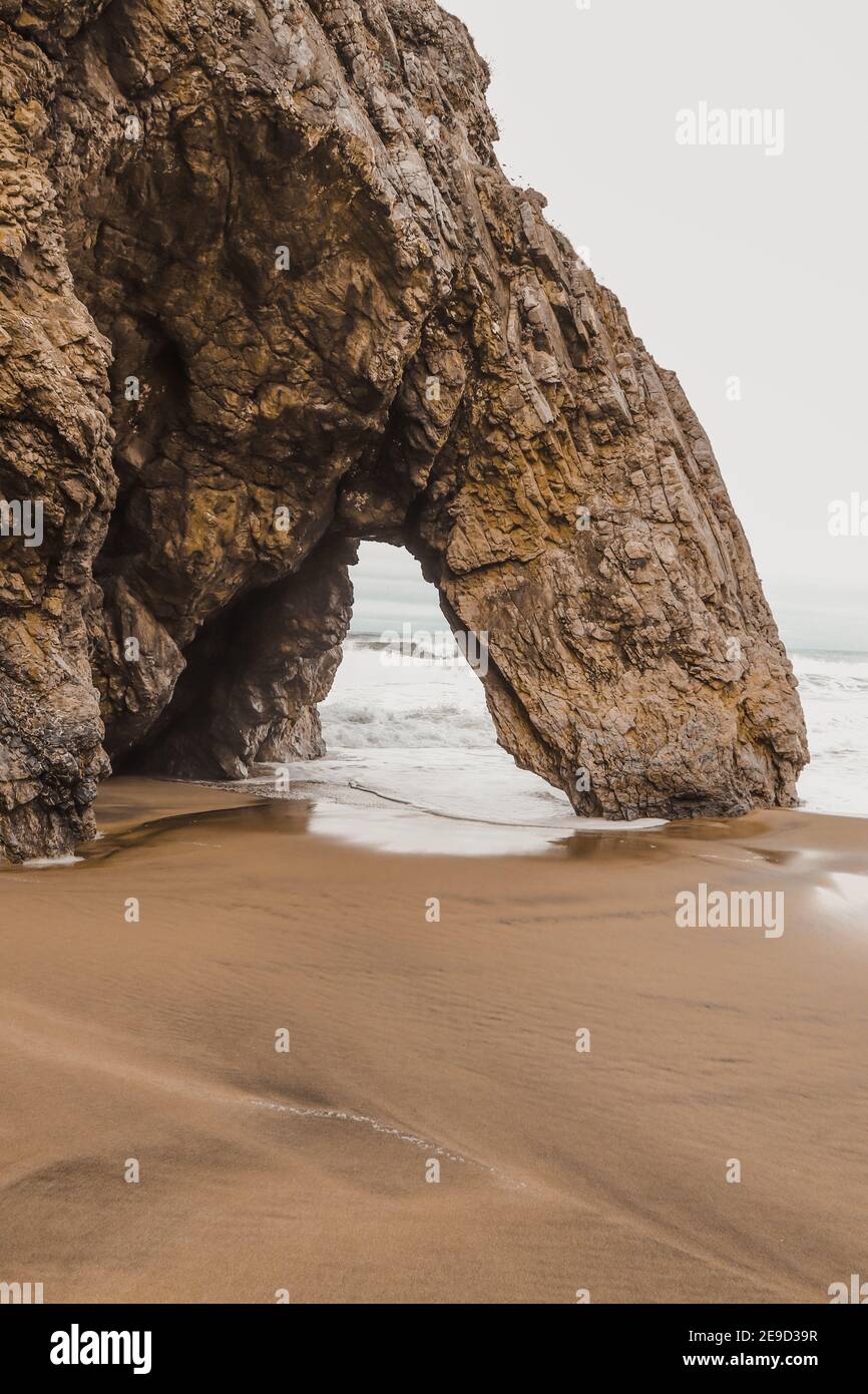 Belle pierre naturelle arche. Formation de roches dans une plage avec l'océan en arrière-plan. Banque D'Images