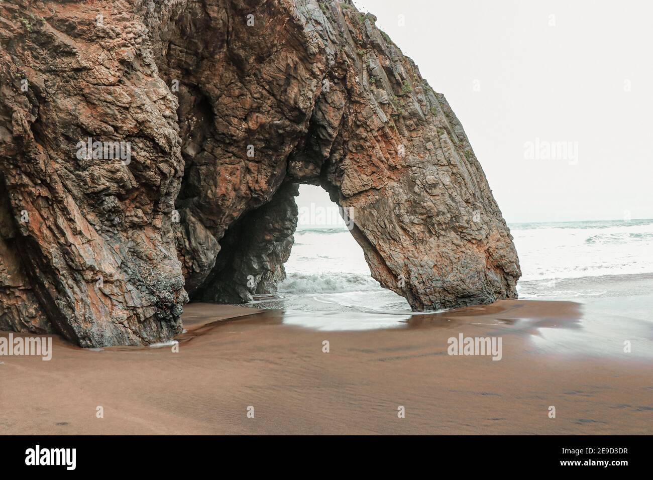 Belle pierre naturelle arche. Formation de roches dans une plage avec l'océan en arrière-plan. Banque D'Images
