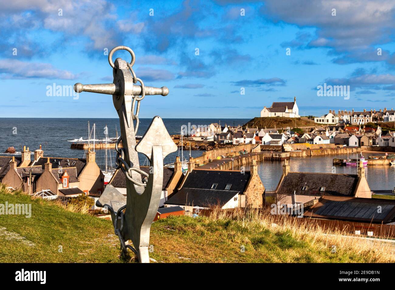 FINDOCHTY MORAY CÔTE ÉCOSSE VUE SUR LA BAIE ET LE PORT AVEC UNE ANCRE ET UNE ÉGLISE BLANCHE SUR LA COLLINE Banque D'Images