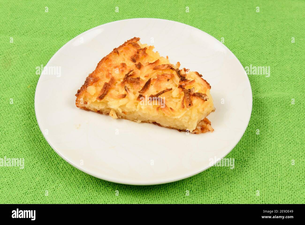 Gâteau de manioc entier sur fond de tissu vert. Banque D'Images