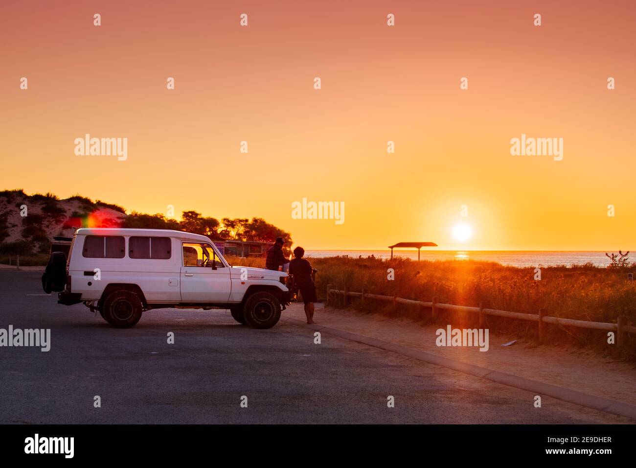 Le coucher de soleil typique de la plage à Coral Bay, Australie occidentale. Bières et 4x4. Banque D'Images