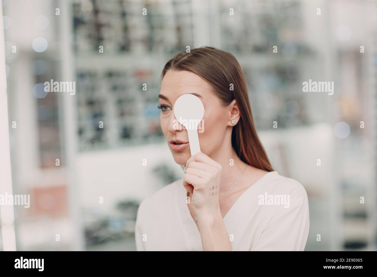 Portrait d'une jeune femme heureuse pendant un examen oculaire à l'opticien optométriste. Banque D'Images